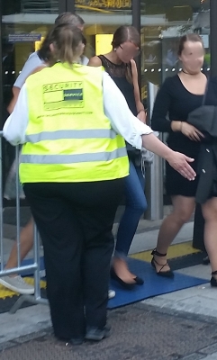 Leicht übergewichtige Frau im Securitydienst bei einem Volksfest